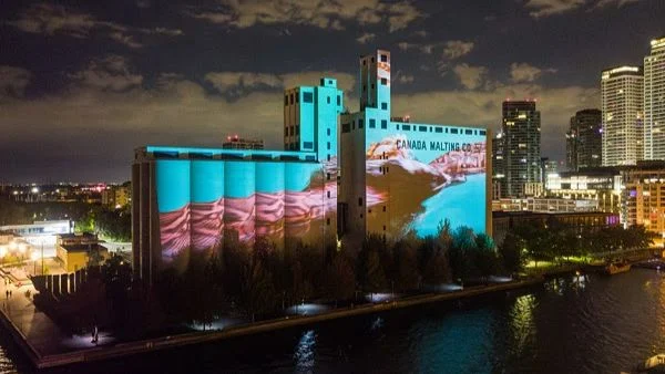A drone shot of a video game projection on the Canada Malting Co. building.